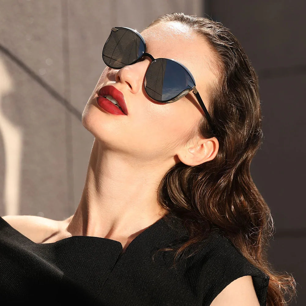 a woman wearing sunglasses and a black dress