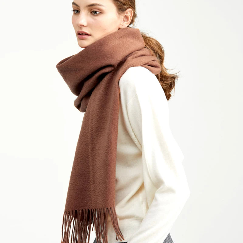 a woman wearing a brown scarf and jeans