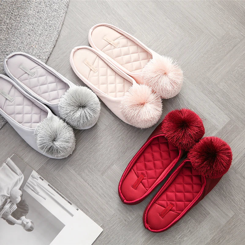 three pairs of slippers with pom poms on them