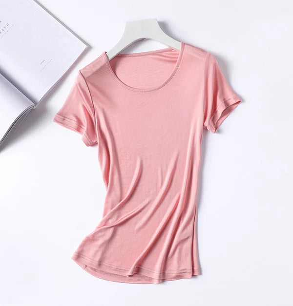 a women's t - shirt on a hanger next to an open book