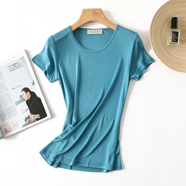 a women's t - shirt next to a magazine and a hat