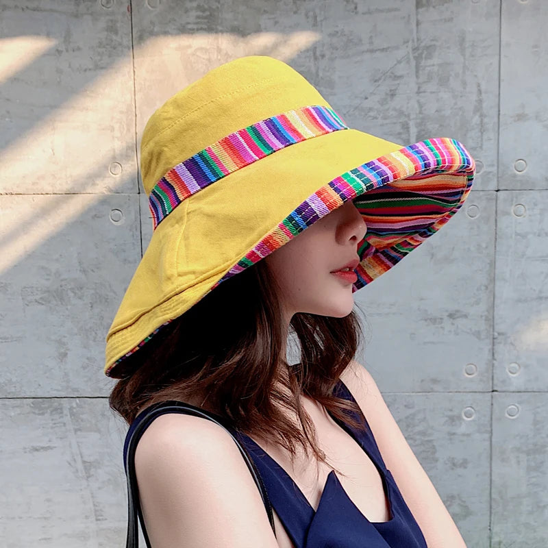 a woman wearing a yellow hat with colorful stripes