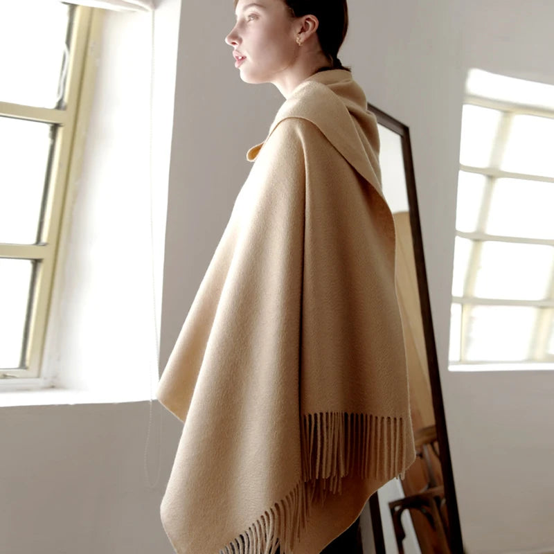 a woman standing in front of a mirror wearing a shawl