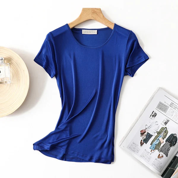 a women's blue shirt next to a hat and a magazine