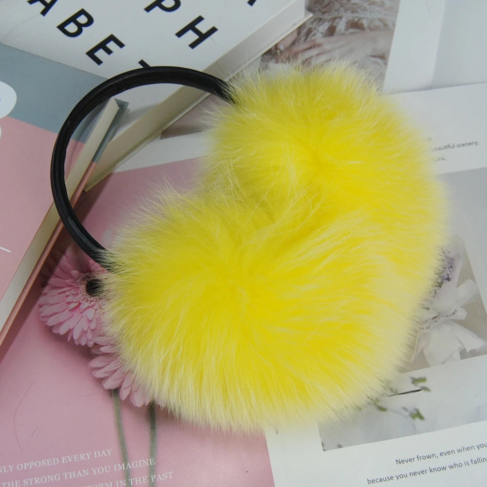 a yellow furry ball keychain sitting on top of a book