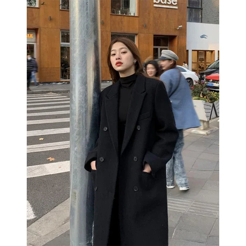 a woman standing next to a pole on a city street