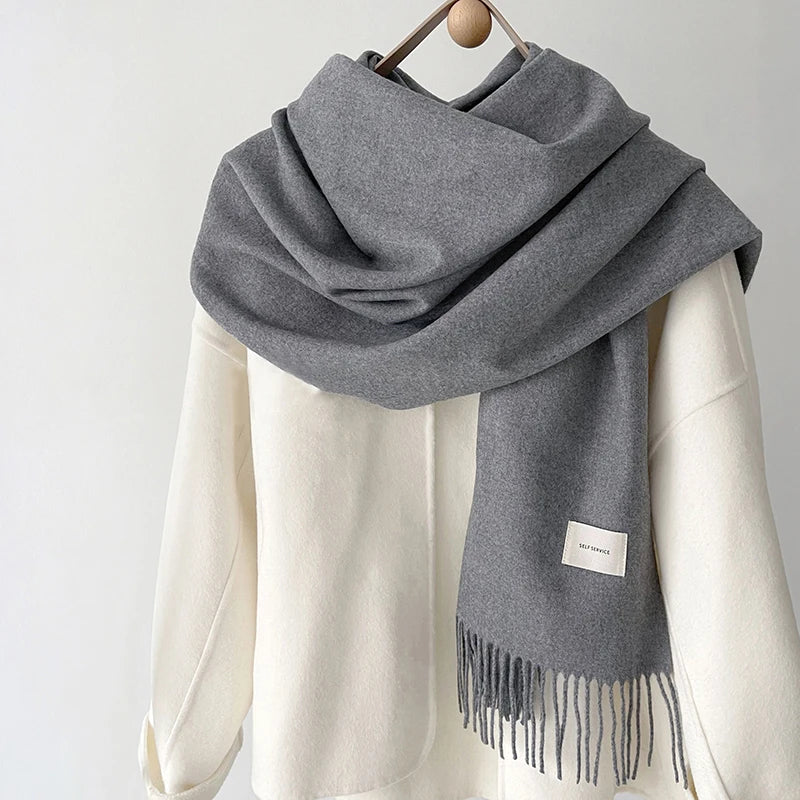 a gray and white scarf hanging on a coat rack