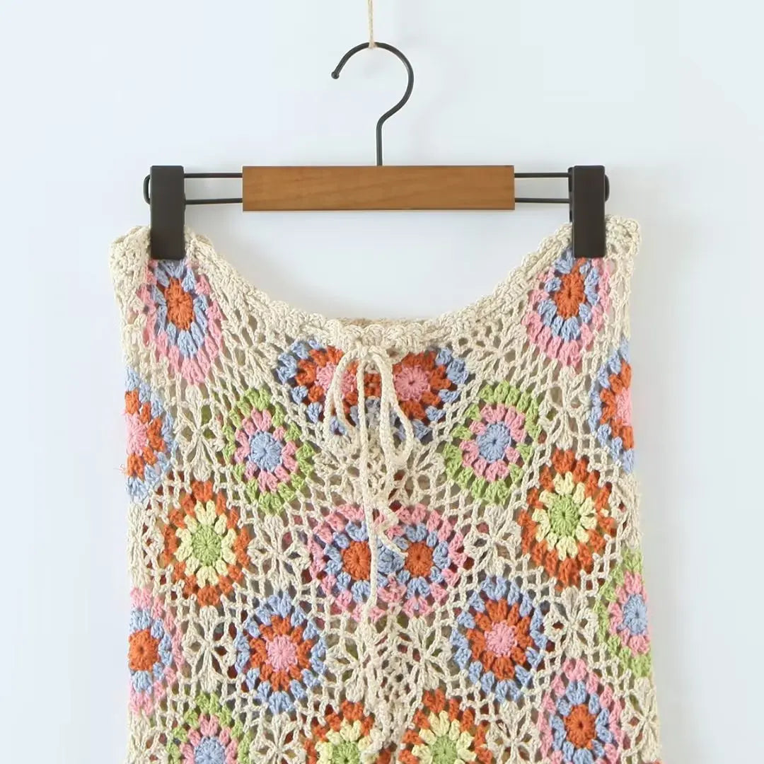 a crocheted top hanging on a wooden hanger