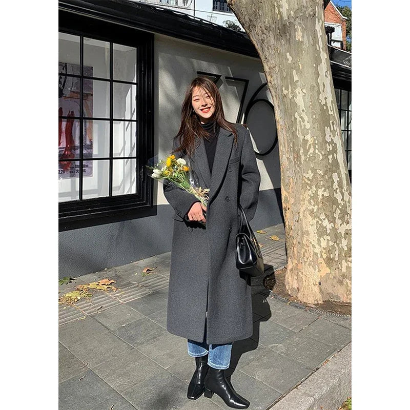 a woman standing on a sidewalk holding a bouquet of flowers