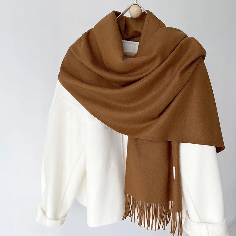 a brown and white scarf hanging on a coat rack