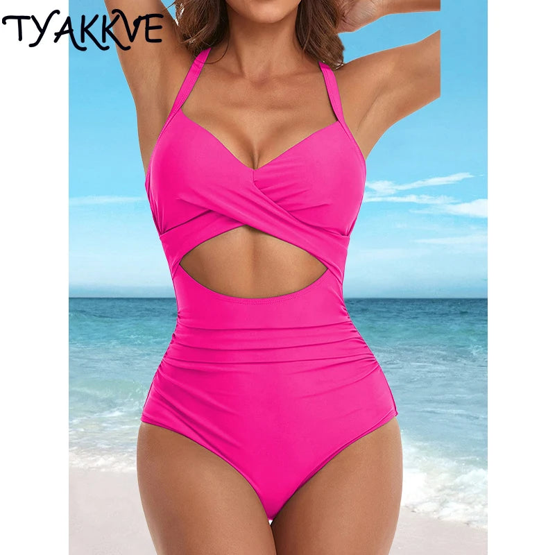 a woman in a pink one piece swimsuit on the beach