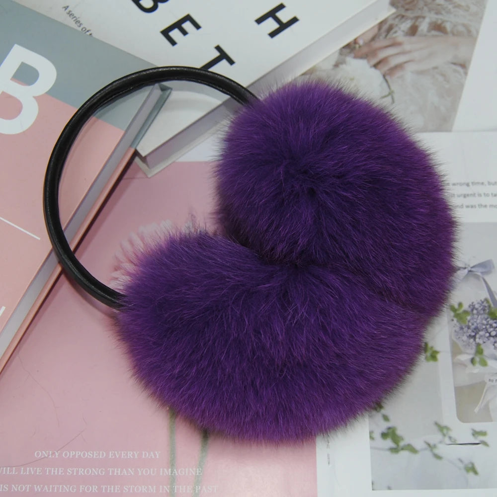 a pair of purple furry ball headphones sitting on top of a magazine