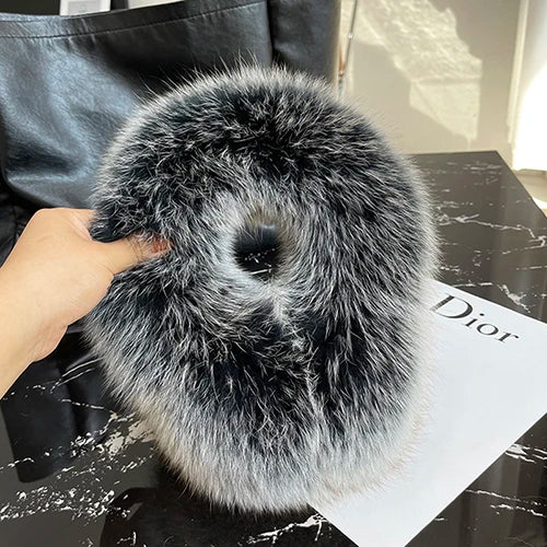 a person holding a fur bag on top of a table