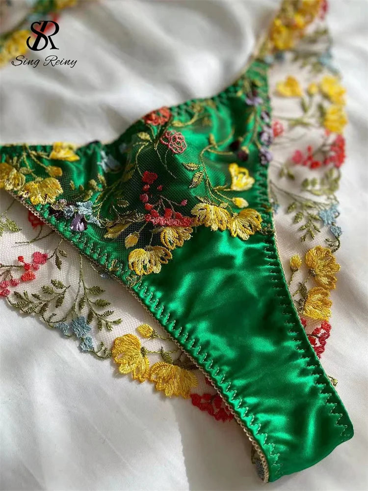 a close up of a green bra with flowers on it