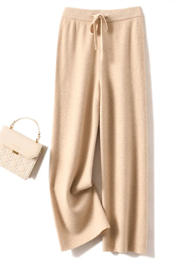 a pair of beige pants and a white purse