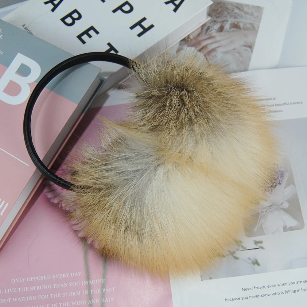 a furry ball laying on top of a book next to a magnifying glass