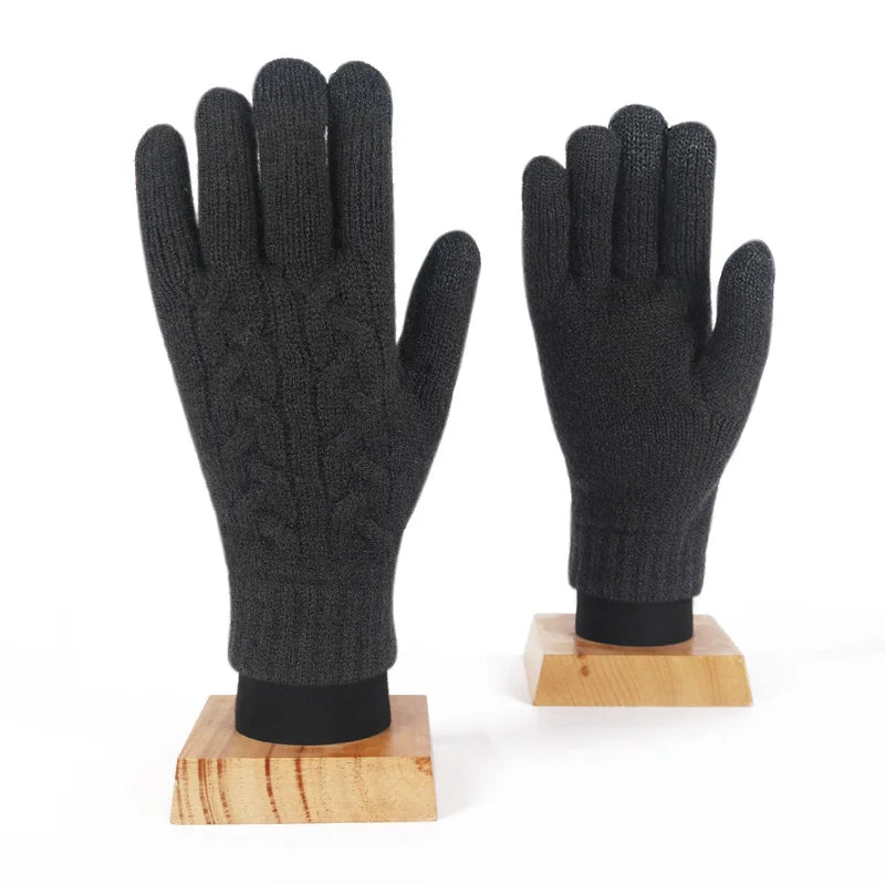 a pair of black gloves sitting on top of a wooden stand