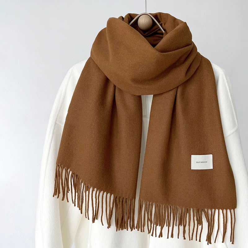 a brown and white scarf hanging on a coat rack