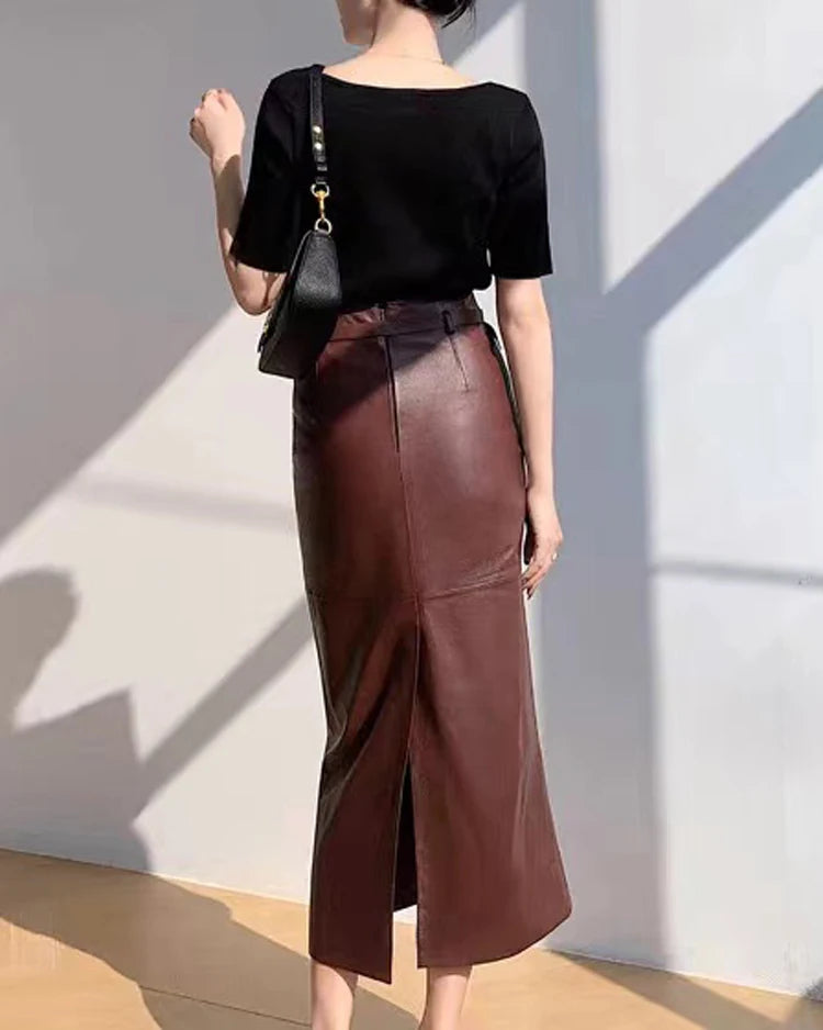 a woman in a black top and brown leather skirt