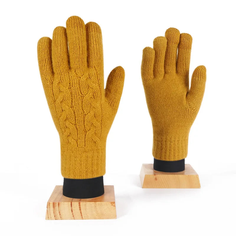 a pair of yellow knitted gloves sitting on top of a wooden stand