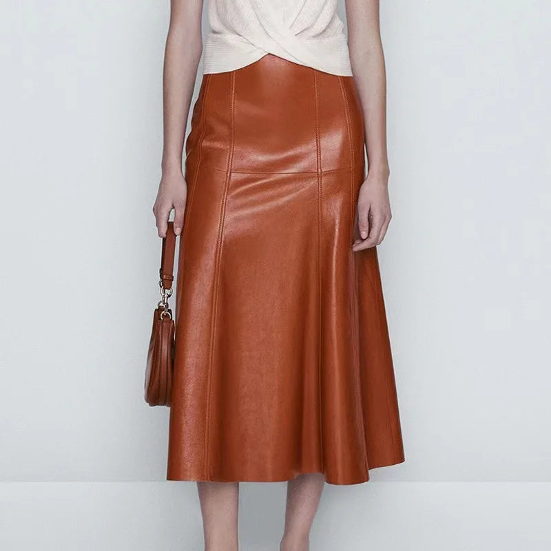 a woman in a white top and brown leather skirt