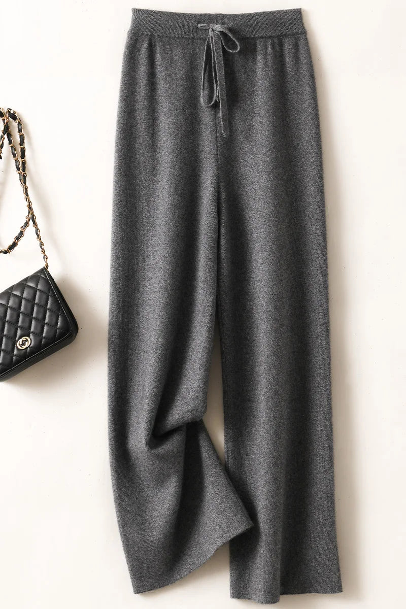 a pair of gray pants with a black purse next to it