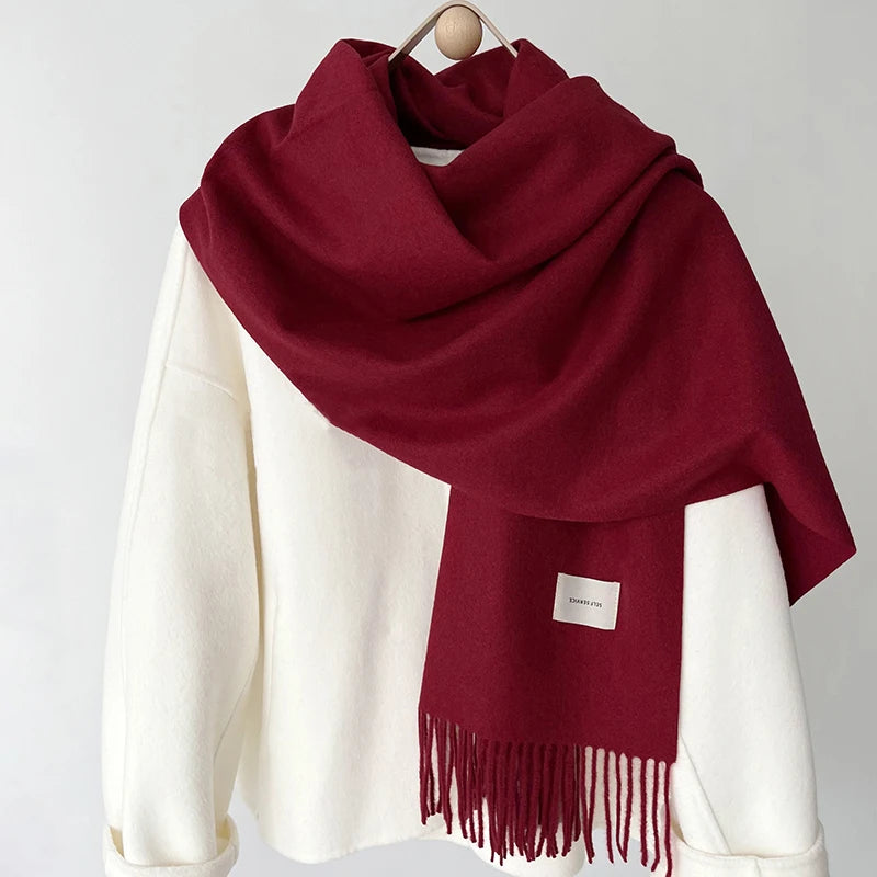 a red and white scarf hanging on a coat rack