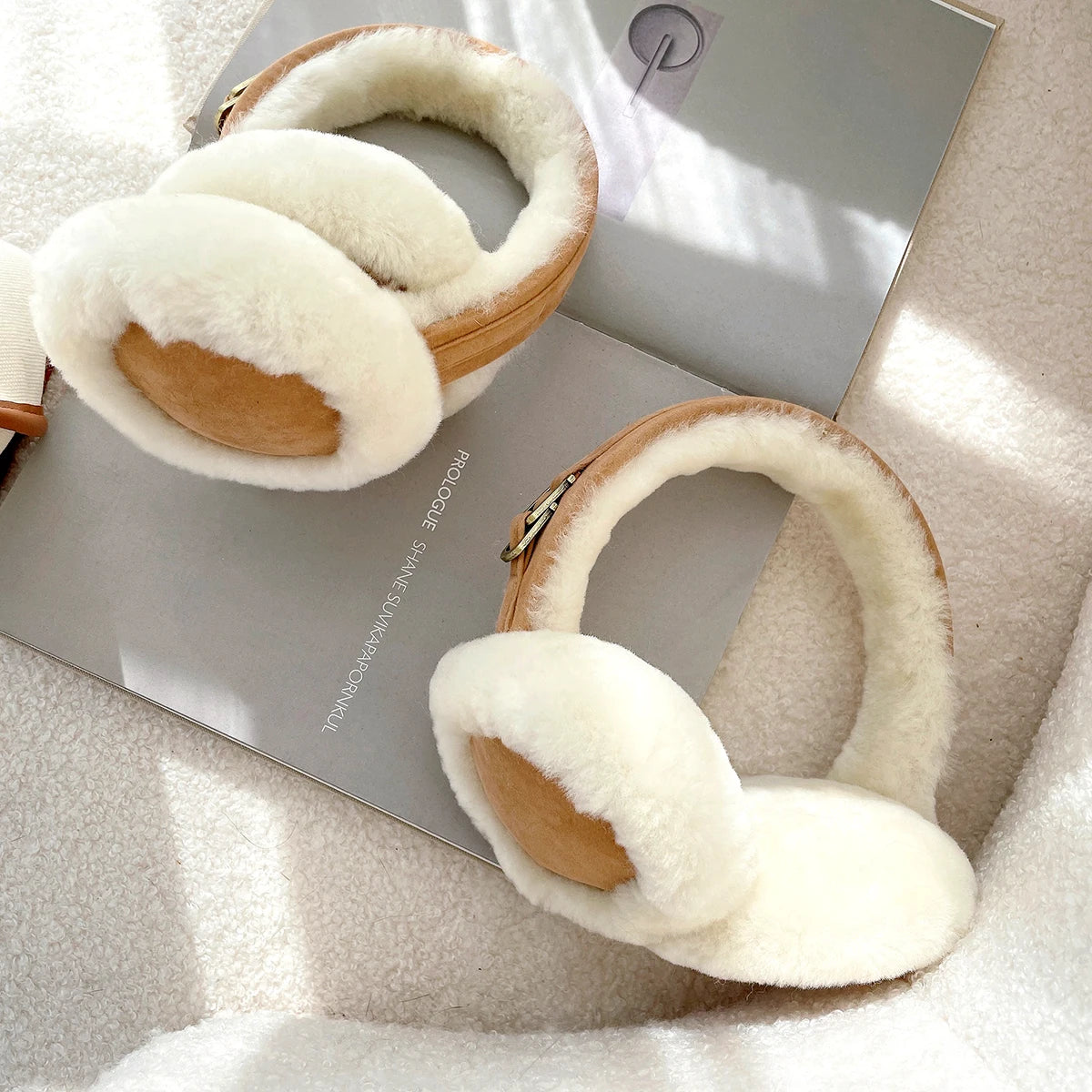 a pair of white ear muffs sitting on top of a book