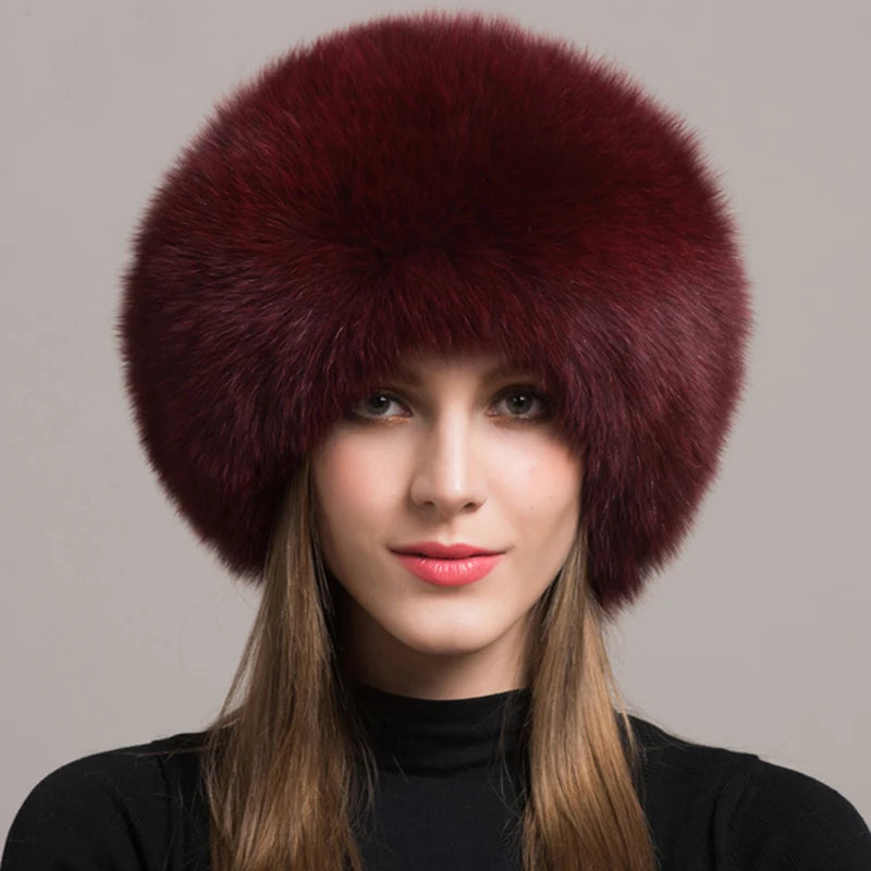 Elegant burgundy natural fox fur hat worn by a model, showcasing deep color and cozy design.