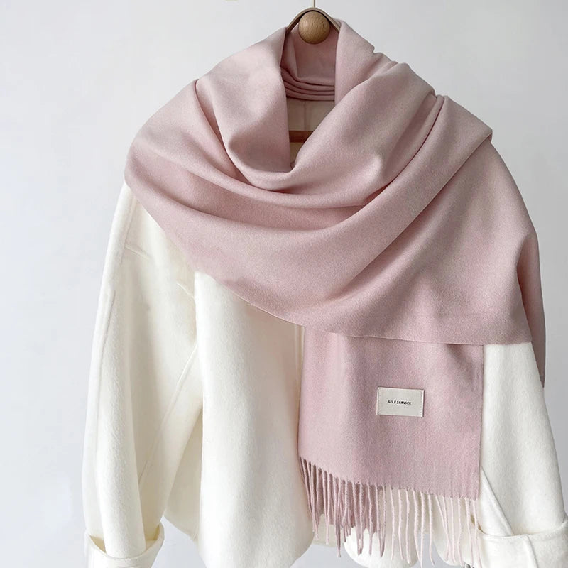 a pink and white scarf hanging on a coat rack