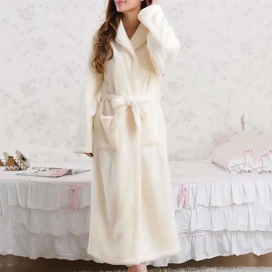 a woman in a bathrobe standing in front of a bed