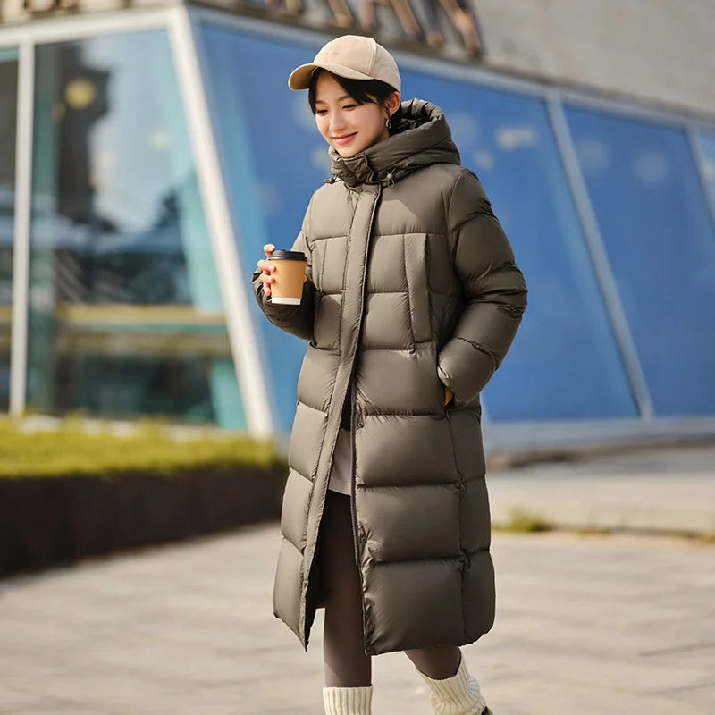 a woman walking down a sidewalk while holding a cup of coffee