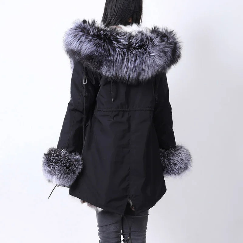 a woman in a black parka with a fur collar