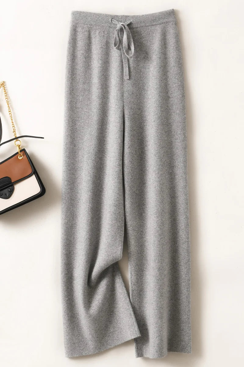 a pair of grey sweat pants next to a purse