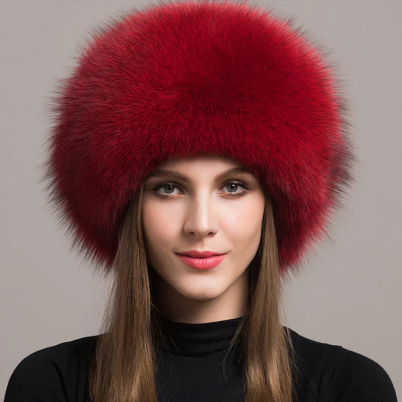 Striking red natural fox fur hat sported by a model, showcasing its plush texture and elegance.