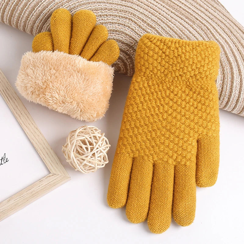 a pair of yellow gloves and a ball of yarn