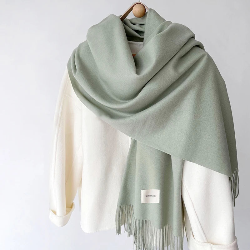 a green and white scarf hanging on a coat rack