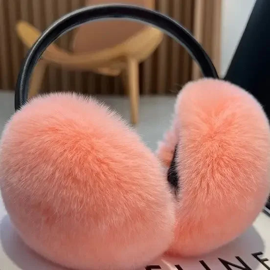 a pair of pink ear muffs sitting on top of a table