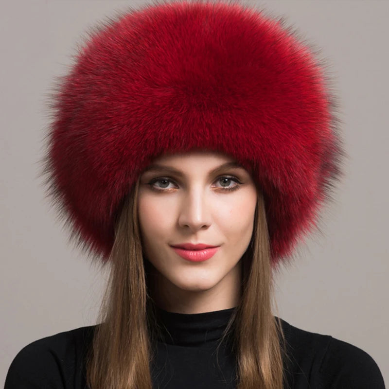 Stylish red natural fox fur hat on a model, featuring a vibrant color and plush texture.