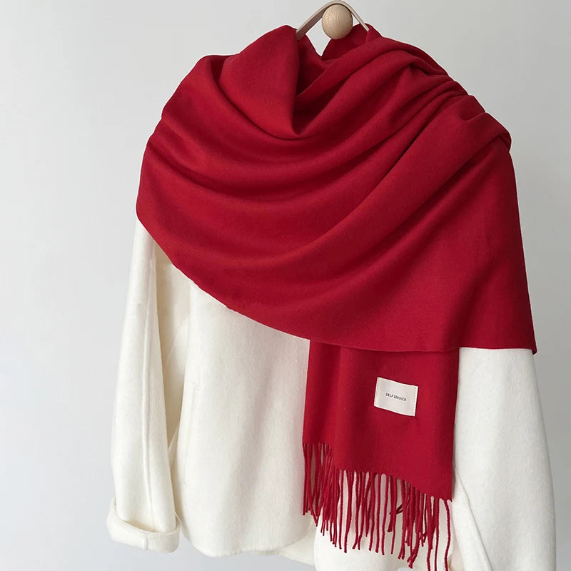 a red and white scarf hanging on a coat rack