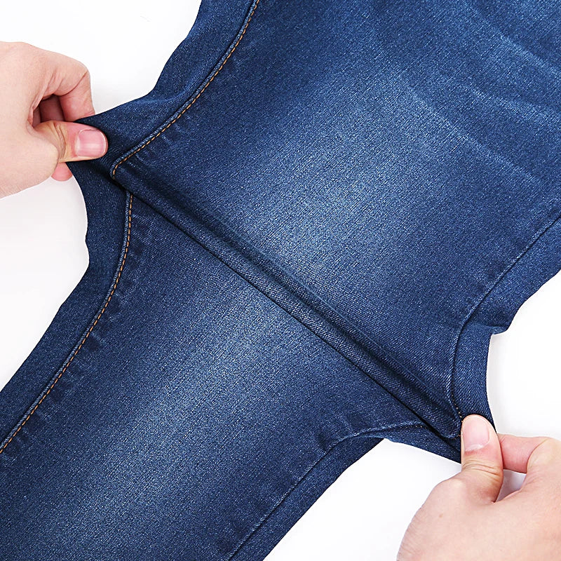 a person cutting a pair of jeans with a pair of scissors