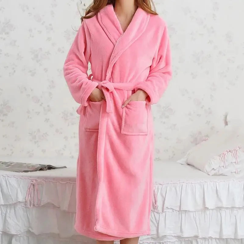 a woman in a pink robe standing on a bed