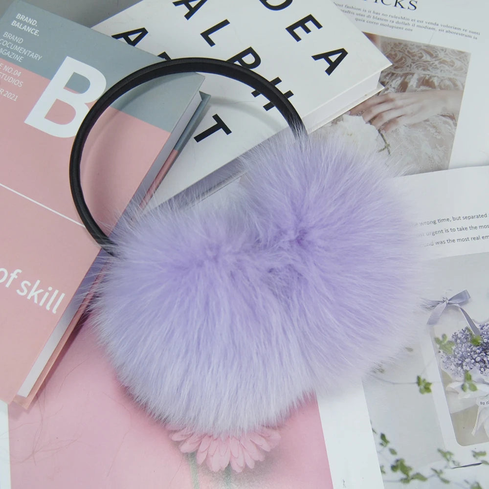 a purple pom pom on top of a magazine and a pair of scissors