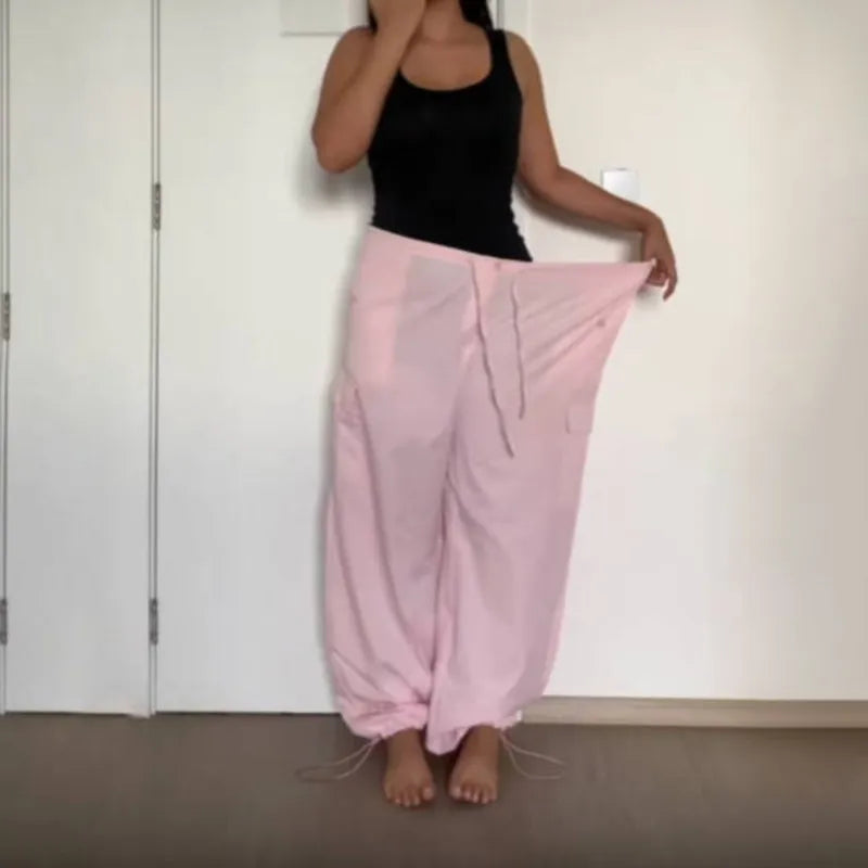 a woman in a black tank top and pink pants