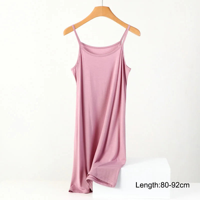 a pink tank top hanging on a wooden hanger