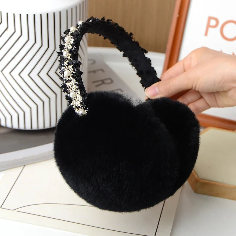 a woman is holding a black furry headband