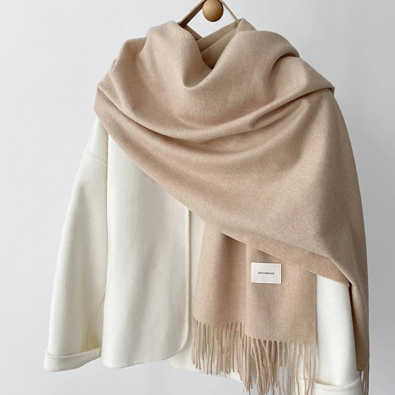 a beige and white scarf hanging on a coat rack