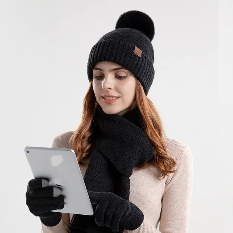 a woman wearing a black hat and scarf holding a tablet