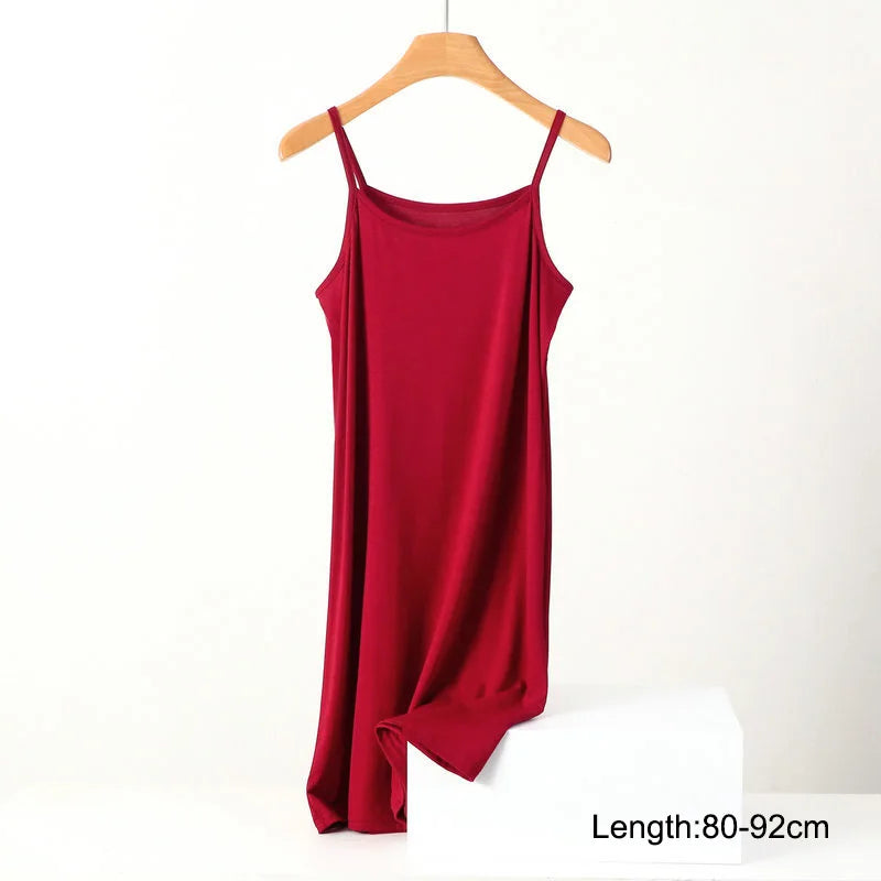 a red tank top hanging on a wooden hanger