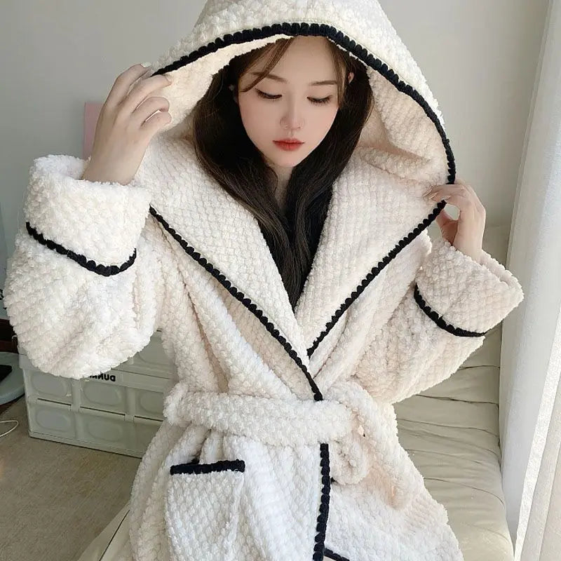 a woman in a bathrobe standing on a bed